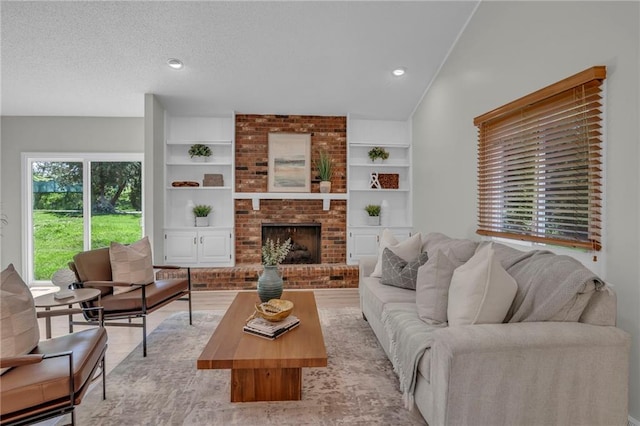 14 Woodbridge Ln, Kansas City, MO 64145 - living room featuring a brick fireplace, built in shelves, and a textured ceiling