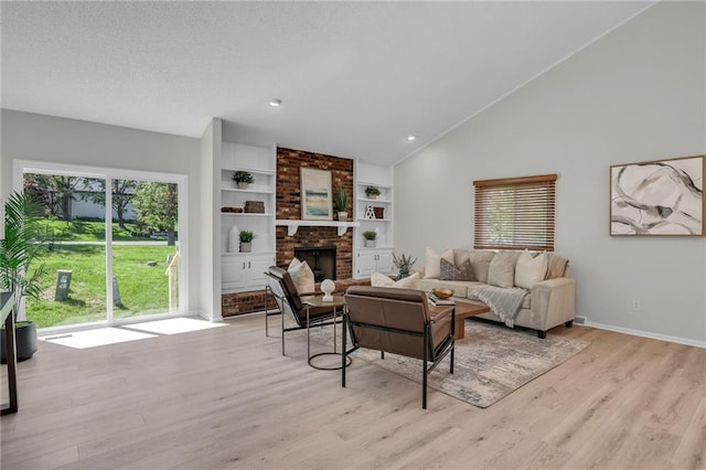 14 Woodbridge Ln, Kansas City, MO 64145 - living area with vaulted ceiling, light wood finished floors, a fireplace, and baseboards