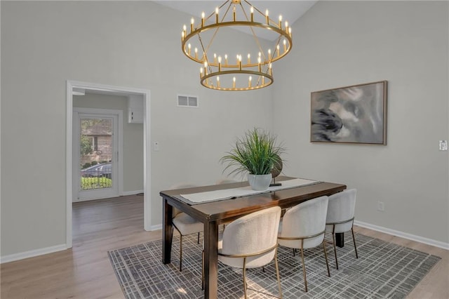 14 Woodbridge Ln, Kansas City, MO 64145 - dining area with a chandelier, wood finished floors, high vaulted ceiling, and baseboards