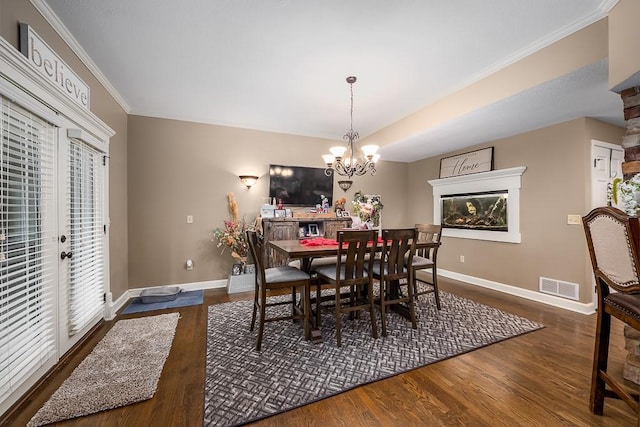 9500 Georgia Ave, Kansas City, KS 66109 - dining area with crown molding, wood finished floors, baseboards, a chandelier, and a fireplace