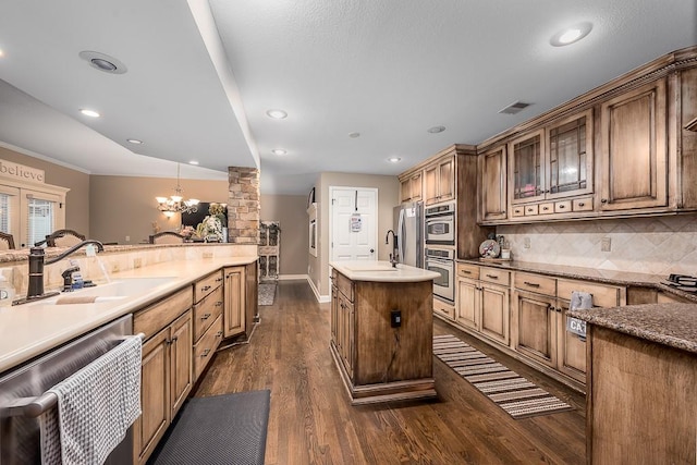 9500 Georgia Ave, Kansas City, KS 66109 - kitchen with dishwashing machine, a sink, a chandelier, backsplash, and dark wood finished floors