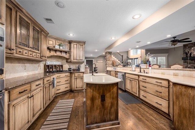9500 Georgia Ave, Kansas City, KS 66109 - kitchen with stainless steel dishwasher, a kitchen island with sink, dark wood-style floors, tasteful backsplash, and recessed lighting
