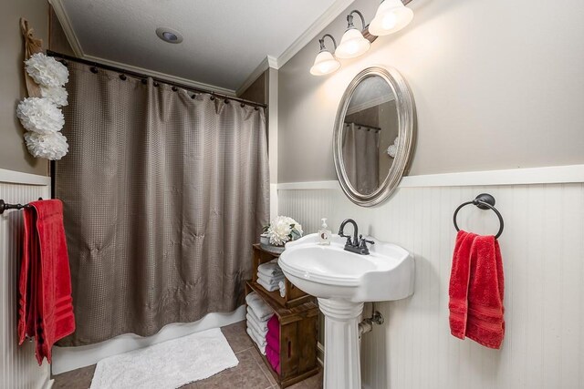 9500 Georgia Ave, Kansas City, KS 66109 - full bath featuring ornamental molding, wainscoting, tile patterned floors, and a sink