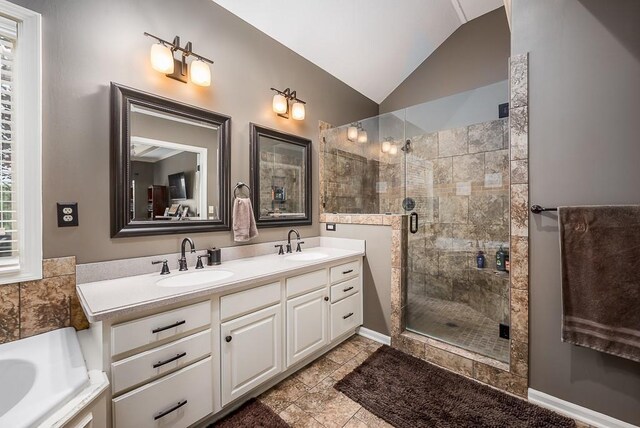9500 Georgia Ave, Kansas City, KS 66109 - full bathroom with vaulted ceiling, a stall shower, double vanity, and a tub