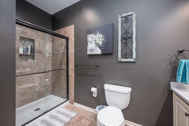 9500 Georgia Ave, Kansas City, KS 66109 - bathroom with a stall shower, toilet, baseboards, and vanity