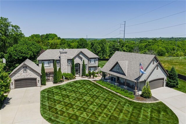 9500 Georgia Ave, Kansas City, KS 66109 - view of front facade featuring concrete driveway, stone siding, and a front yard