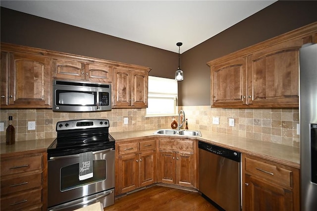 8941 NE 116th Pl, Kansas City, MO 64157 - kitchen featuring stainless steel appliances, a sink, hanging light fixtures, and backsplash