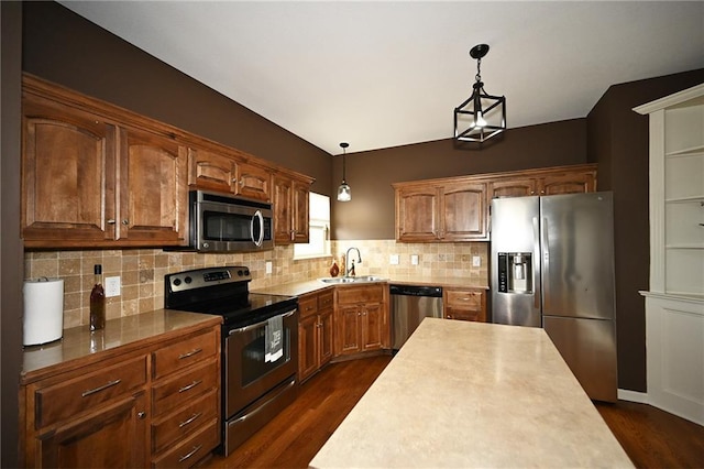 8941 NE 116th Pl, Kansas City, MO 64157 - kitchen with appliances with stainless steel finishes, a sink, hanging light fixtures, dark wood-type flooring, and decorative backsplash
