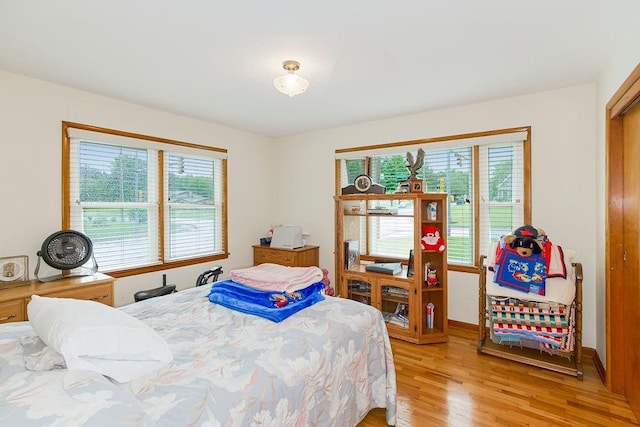 911 Limit St, Leavenworth, KS 66048 - bedroom featuring multiple windows, light wood-style flooring, and baseboards