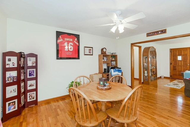 911 Limit St, Leavenworth, KS 66048 - dining area featuring light wood finished floors, arched walkways, a ceiling fan, and baseboards