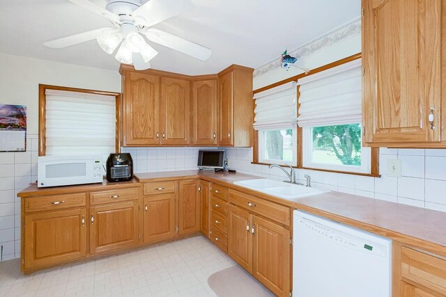 911 Limit St, Leavenworth, KS 66048 - kitchen featuring white appliances, a sink, ceiling fan, light countertops, and tile walls