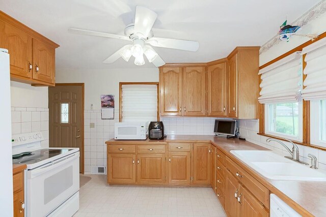 911 Limit St, Leavenworth, KS 66048 - kitchen with white appliances, a sink, light countertops, ceiling fan, and brown cabinets