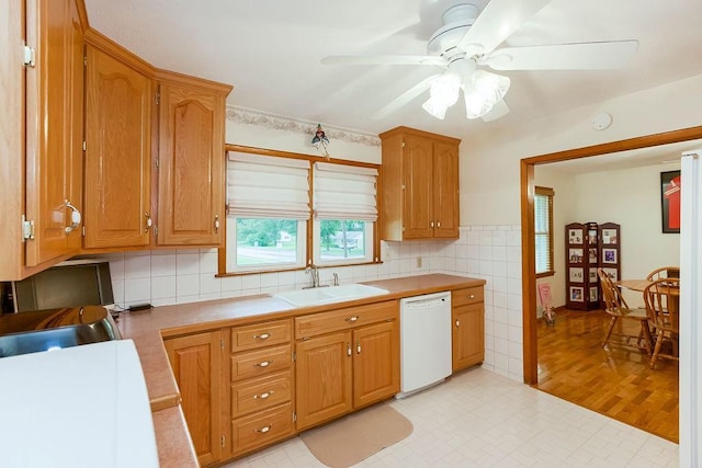 911 Limit St, Leavenworth, KS 66048 - kitchen featuring dishwasher, a sink, ceiling fan, backsplash, and tile counters