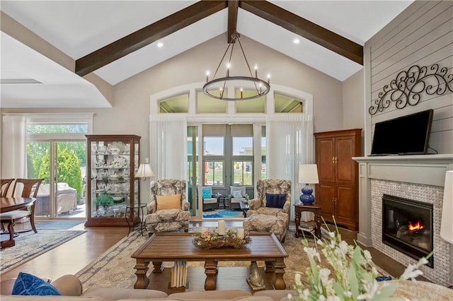 living room with beam ceiling, a tile fireplace, a chandelier, wood finished floors, and high vaulted ceiling