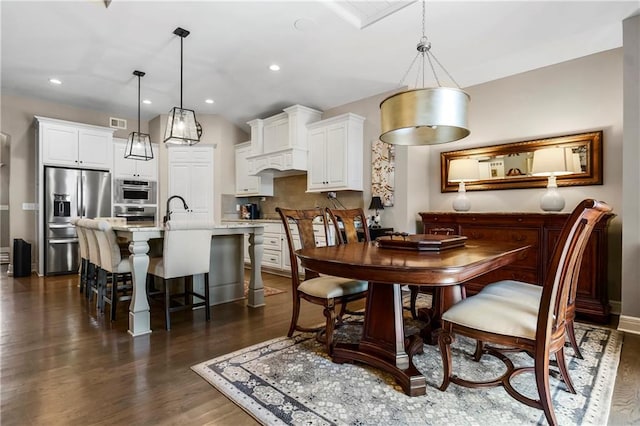 dining room featuring dark wood finished floors, recessed lighting, and baseboards