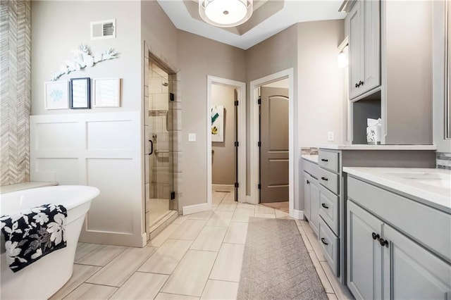 bathroom with a stall shower, vanity, and a freestanding bath
