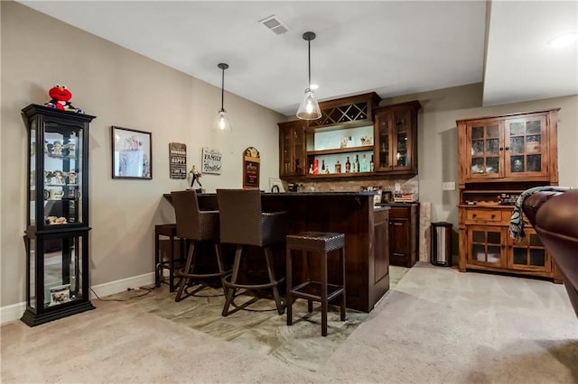 indoor wet bar with light carpet, pendant lighting, and baseboards
