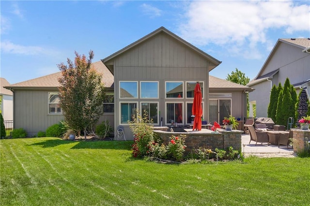 rear view of house featuring a patio area, an outdoor hangout area, a yard, and roof with shingles