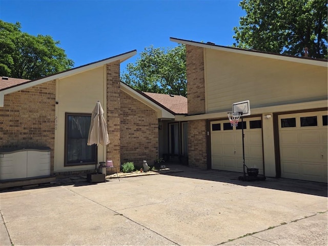 2500 N 10th St, Independence, KS 67301 - view of side of property with concrete driveway, brick siding, and an attached garage