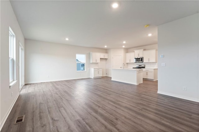 2114 Creek View Ln, Raymore, MO 64083 - unfurnished living room with recessed lighting, dark wood-style floors, baseboards, and a sink