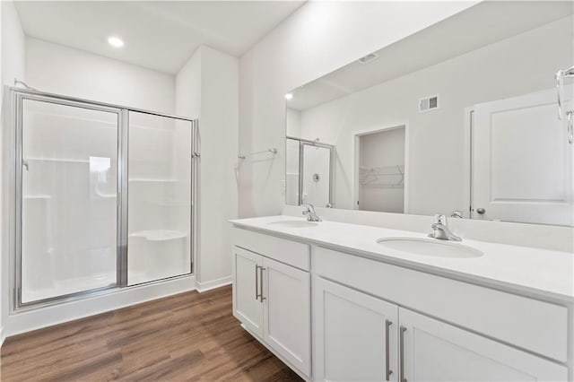 2114 Creek View Ln, Raymore, MO 64083 - bathroom featuring a shower stall, wood finished floors, a spacious closet, double vanity, and recessed lighting