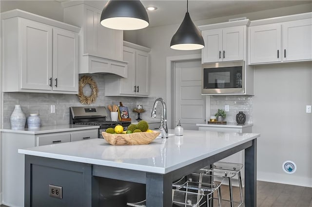 5854 Mccormick Dr, Shawnee, KS 66226 - kitchen featuring appliances with stainless steel finishes, light countertops, white cabinets, a kitchen bar, and tasteful backsplash