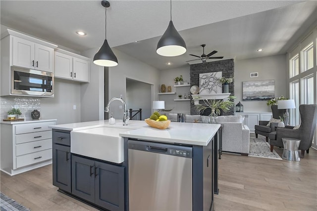 5854 Mccormick Dr, Shawnee, KS 66226 - kitchen with appliances with stainless steel finishes, a sink, ceiling fan, white cabinets, and light countertops