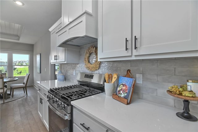 5854 Mccormick Dr, Shawnee, KS 66226 - kitchen with stainless steel gas range, light countertops, custom range hood, and light wood-type flooring