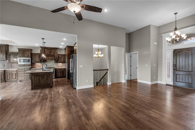 12750 N Arbor Way, Platte City, MO 64079 - unfurnished living room with a chandelier, ceiling fan, baseboards, dark wood finished floors, and a high ceiling