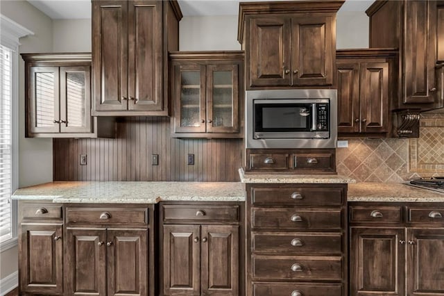 12750 N Arbor Way, Platte City, MO 64079 - kitchen featuring stainless steel microwave, dark brown cabinets, decorative backsplash, and plenty of natural light