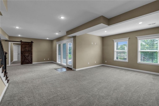 12750 N Arbor Way, Platte City, MO 64079 - unfurnished living room featuring a barn door, carpet flooring, baseboards, and recessed lighting