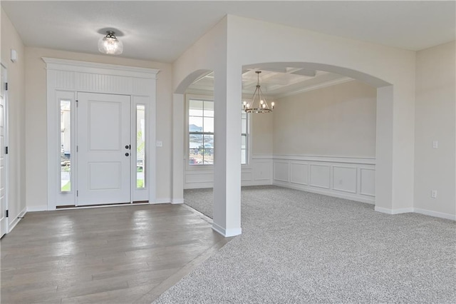 111 N Singletree St, Olathe, KS 66061 - foyer entrance featuring arched walkways, a chandelier, and hardwood / wood-style flooring
