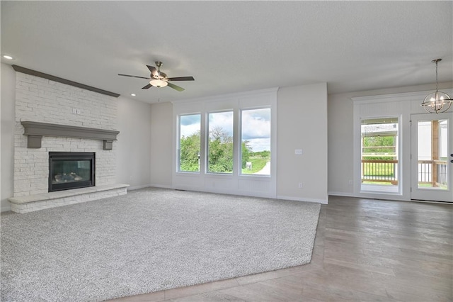 111 N Singletree St, Olathe, KS 66061 - unfurnished living room with ceiling fan, baseboards, a textured ceiling, a fireplace, and wood finished floors