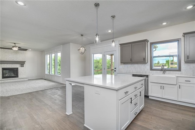 111 N Singletree St, Olathe, KS 66061 - kitchen featuring stainless steel dishwasher, a sink, a ceiling fan, a textured ceiling, and light countertops