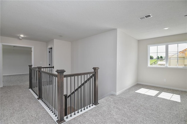 111 N Singletree St, Olathe, KS 66061 - hallway featuring carpet flooring, a textured ceiling, an upstairs landing, and baseboards