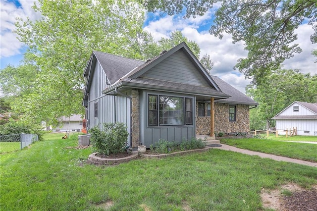 313 SW Ensley Ln, Lees Summit, MO 64081 - view of front of property featuring a shingled roof, stone siding, board and batten siding, and central AC unit
