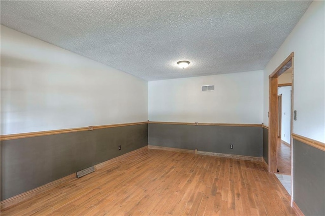 313 SW Ensley Ln, Lees Summit, MO 64081 - unfurnished room featuring light wood-style flooring, a textured ceiling, and baseboards