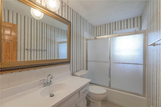 313 SW Ensley Ln, Lees Summit, MO 64081 - bathroom featuring wallpapered walls, toilet, vanity, combined bath / shower with glass door, and a textured ceiling
