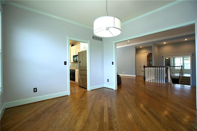 spare room with baseboards, crown molding, and dark wood finished floors