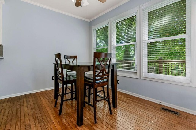 dining space featuring crown molding, hardwood / wood-style flooring, baseboards, and a ceiling fan