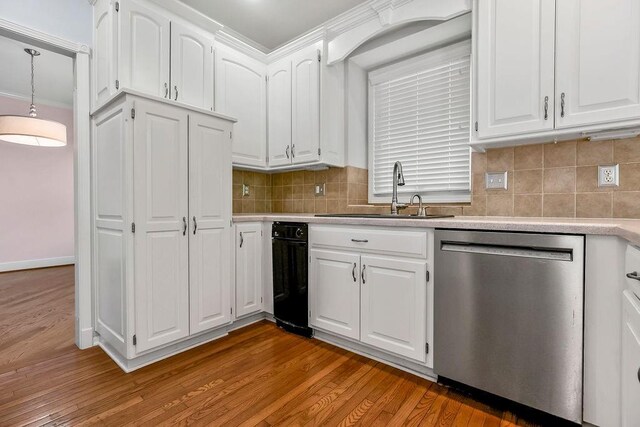kitchen with stainless steel dishwasher, a sink, light countertops, white cabinetry, and wood finished floors