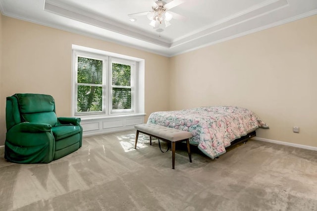 bedroom featuring a tray ceiling, crown molding, carpet floors, and ceiling fan
