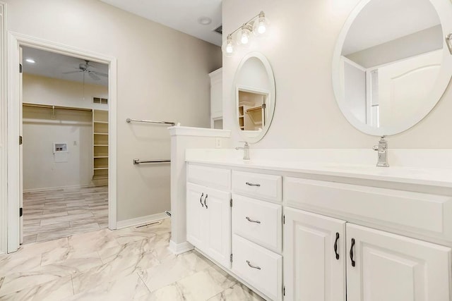 bathroom with a ceiling fan, marble look tile flooring, a walk in closet, and double vanity