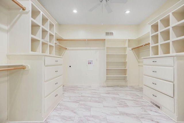 spacious closet with a ceiling fan and light marble finish floors