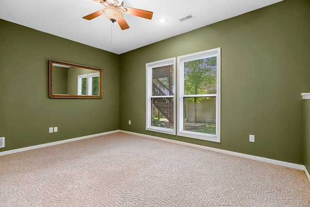 carpeted empty room with baseboards and ceiling fan