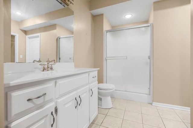 bathroom featuring a stall shower, toilet, tile patterned flooring, vanity, and baseboards