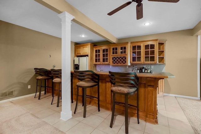 indoor wet bar with white refrigerator with ice dispenser, a ceiling fan, baseboards, light tile patterned flooring, and recessed lighting