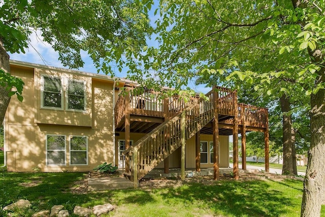 back of house featuring a yard, a wooden deck, and stairway