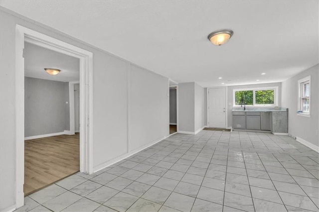 empty room featuring baseboards and light tile patterned flooring