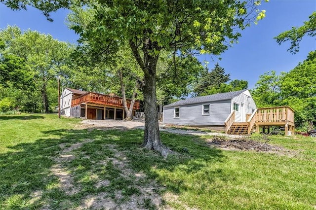 view of green lawn with a wooden deck